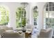 Bright and airy sitting room featuring four comfortable chairs, decorative chandelier and views of the greenery outside at 315 Peachtree Battle Nw Ave, Atlanta, GA 30305