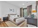 Bright bedroom featuring neutral tones, wood floors, and a sliding glass door to a balcony at 112 Rogers Ne St # 207, Atlanta, GA 30317