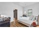 Bedroom area featuring a full bed, modern dresser and desk, wood floors, and a full window at 112 Rogers Ne St # 207, Atlanta, GA 30317