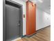 Hallway leading to apartment unit 207 with hardwood floors and modern sconce at 112 Rogers Ne St # 207, Atlanta, GA 30317