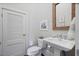 Charming powder room with a pedestal sink, framed mirror, and stylish fixtures at 645 Iroquois Ne Dr, Marietta, GA 30060