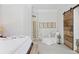 Relaxing bedroom with white walls, chair and wood barn door to bathroom at 645 Iroquois Ne Dr, Marietta, GA 30060