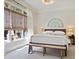 Well-lit bedroom with neutral decor, large window, and bench at the end of the bed at 645 Iroquois Ne Dr, Marietta, GA 30060