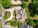 Aerial view of a home showcasing its well-manicured landscaping, circular driveway, and mature trees at 6935 Wakehurst Pl, Cumming, GA 30040