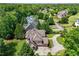 Aerial view of a house with a circular driveway, three car garage, and lush greenery surrounding it at 6935 Wakehurst Pl, Cumming, GA 30040