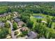 Gorgeous aerial view of neighborhood homes and golf course with a pond and green landscape at 6935 Wakehurst Pl, Cumming, GA 30040