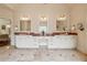 Large primary bath features three sinks and vanities. Bathed in neutral colors with marble floors and countertops at 6935 Wakehurst Pl, Cumming, GA 30040