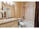 Neutral bathroom featuring cream vanity with granite countertop and shower-tub with decorative brown shower curtain at 6935 Wakehurst Pl, Cumming, GA 30040