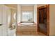 Elegant bathroom featuring a soaking tub with a decorative window and glass shower stall at 6935 Wakehurst Pl, Cumming, GA 30040
