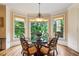 Inviting breakfast nook featuring hardwood floors, large windows, and decorative lighting fixture at 6935 Wakehurst Pl, Cumming, GA 30040