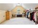 Spacious walk-in closet featuring a window, a large wardrobe and carpeted floors at 6935 Wakehurst Pl, Cumming, GA 30040