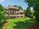 Stunning brick home with well-manicured lawn surrounded by mature trees and lush greenery at 6935 Wakehurst Pl, Cumming, GA 30040