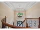 Elegant foyer showcasing a decorative chandelier and staircase with wrought iron detailing at 6935 Wakehurst Pl, Cumming, GA 30040