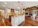 Modern kitchen featuring island, granite countertops, modern appliances, and a fireplace in the adjacent living area at 6935 Wakehurst Pl, Cumming, GA 30040