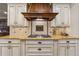 Gas stovetop in gourmet kitchen boasts granite countertops, custom cabinetry, and modern appliances at 6935 Wakehurst Pl, Cumming, GA 30040