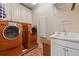 Efficient laundry room equipped with modern washer and dryer units and ample cabinet space at 6935 Wakehurst Pl, Cumming, GA 30040