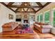 Spacious living room featuring a stone fireplace, exposed beams, and a view of the outdoors at 6935 Wakehurst Pl, Cumming, GA 30040