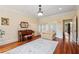 Cozy living room with hardwood floors, piano, and a bay window offering natural light at 6935 Wakehurst Pl, Cumming, GA 30040