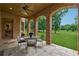 Relaxing outdoor patio features brick archways, stone tile flooring, and scenic backyard views at 6935 Wakehurst Pl, Cumming, GA 30040