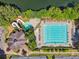 Aerial view of a well-maintained swimming pool and kiddie pool area with water slide, surrounded by lush greenery at 6935 Wakehurst Pl, Cumming, GA 30040