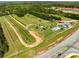 Aerial view showcases a large Bedroom with rows of plants, playground equipment, and buildings nearby a roadway at 209 Brynn Ln, Mcdonough, GA 30252