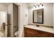 Bathroom showcasing a granite countertop, wood cabinetry, and a framed mirror at 209 Brynn Ln, Mcdonough, GA 30252