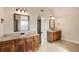 Well-lit bathroom featuring dual vanities with granite countertops and warm wood cabinetry at 209 Brynn Ln, Mcdonough, GA 30252