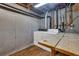 The laundry area in the basement features concrete walls and wood top folding table at 2763 Macby Walk, Marietta, GA 30066