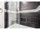 Dark tiled shower with glass door and white trim and built in nook at 2760 Swansea Ct, College Park, GA 30349