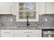 Modern kitchen sink and faucet beneath a window, complemented by granite countertops and a tile backsplash at 2760 Swansea Ct, College Park, GA 30349
