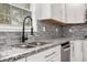Close up of the kitchen sink, faucet, granite counters, gray backsplash, and a window with black trim at 2760 Swansea Ct, College Park, GA 30349