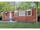 Traditional brick home featuring a front porch, red shutters, and green lawn at 299 Ard Nw Pl, Atlanta, GA 30331