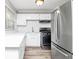 A bright kitchen with stainless steel appliances, white cabinets, and wood floors at 299 Ard Nw Pl, Atlanta, GA 30331