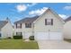 Two-story home featuring a two-car garage, vinyl siding, a well-maintained lawn, and inviting curb appeal at 3943 Brookgate Ct, Ellenwood, GA 30294