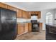 Well-lit kitchen featuring wood cabinets, modern appliances, and stylish wood-look flooring at 3943 Brookgate Ct, Ellenwood, GA 30294