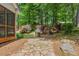 View of the home's backyard with stone patio, stainless steel grill, and lush landscaping at 7675 Rose Ln, Cumming, GA 30040