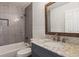 Bathroom vanity featuring a white marble countertop and tiled shower at 7675 Rose Ln, Cumming, GA 30040