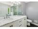 Bright bathroom featuring a double vanity with stone countertop at 7675 Rose Ln, Cumming, GA 30040