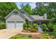Charming home featuring a two-car garage, covered porch, and beautiful landscaping at 7675 Rose Ln, Cumming, GA 30040
