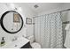 Well-lit bathroom with a circular mirror, modern vanity, and a shower with decorative curtain at 1152 Hampton Ne Way, Atlanta, GA 30324