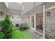 Cozy outdoor courtyard with a brick patio, manicured landscaping, and string lights at 1152 Hampton Ne Way, Atlanta, GA 30324