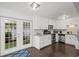 Modern kitchen features white cabinets, stainless steel appliances, granite countertops, and a French door leading outside at 1152 Hampton Ne Way, Atlanta, GA 30324
