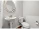 Half-bath with pedestal sink, decorative mirror, and toilet at 1307 Park Center Cir, Austell, GA 30168