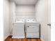 Functional laundry room offers wooden floors, storage shelf, and appliances for convenient chores at 1307 Park Center Cir, Austell, GA 30168