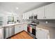 Bright kitchen with modern appliances, white cabinets and a view to dining area at 24 Scarlett Oak Ne Dr, Cartersville, GA 30121