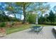 Secluded backyard with a paved patio, outdoor dining set, and mature shade tree at 4455 Sirrocco Sw Ln, Lilburn, GA 30047