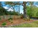 Secluded backyard with mature trees, a shed, and a fenced perimeter at 4455 Sirrocco Sw Ln, Lilburn, GA 30047