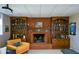 Basement brick fireplace with wood mantle, built-in shelves, and decor at 4455 Sirrocco Sw Ln, Lilburn, GA 30047