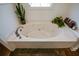 Close-up of a pristine soaker tub with a chrome faucet and neutral-toned tiles at 4455 Sirrocco Sw Ln, Lilburn, GA 30047