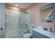 Bathroom with white subway tile, glass shower door, gray vanity, and modern lighting at 4455 Sirrocco Sw Ln, Lilburn, GA 30047